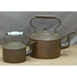 An oversize or large copper kettle together with a further example with glass handle, both with