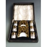 A cased Aynsley coffee set with enamelled decoration the cups in hallmarked silver holders