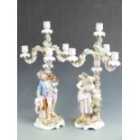 A pair of 19thC German figural candelabra with a monkey and parrot on the figures' shoulders, H 53cm