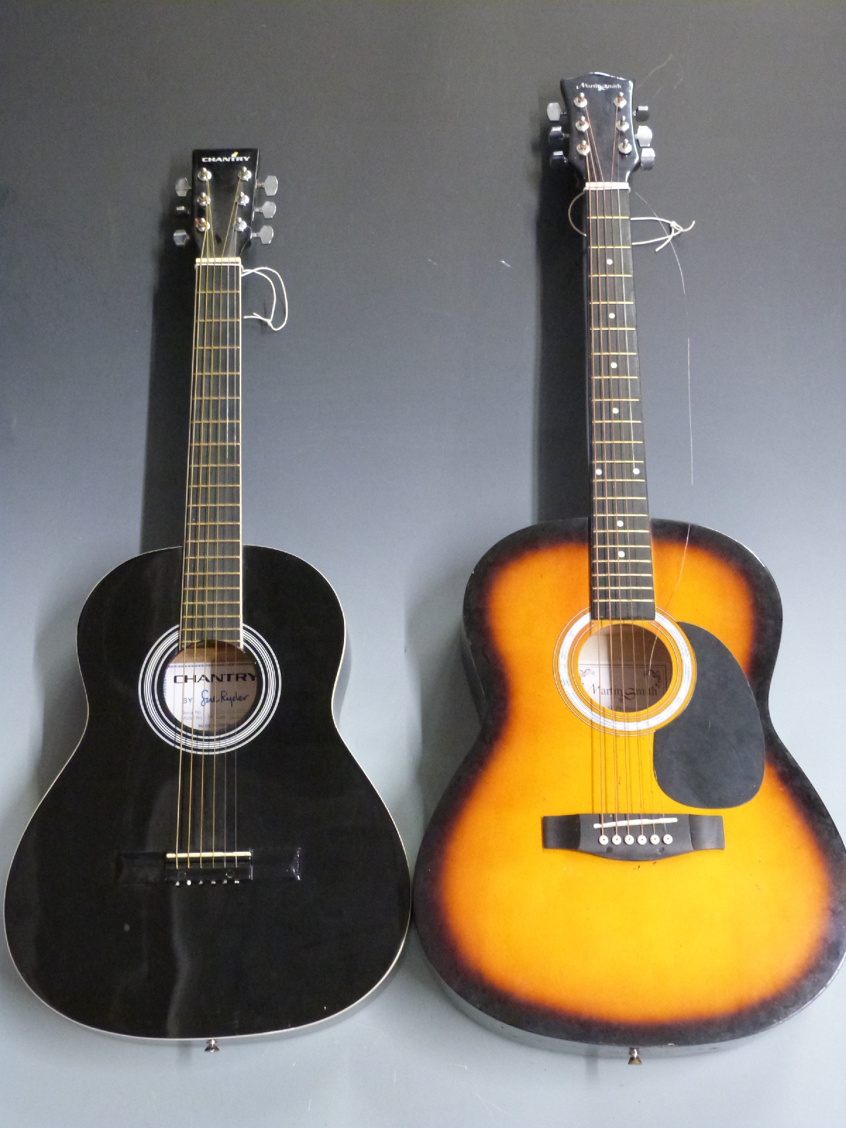 Two acoustic guitars comprising a Martin Smith in flame effect and a Chantry example in black