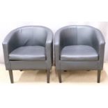 Two faux leather tub chairs raised on square tapering black legs