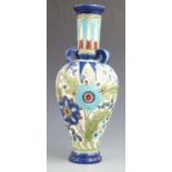 Burmantofts tube lined three handled pedestal vase decorated with flowers and foliage, impressed