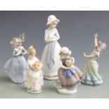 Nao figurine of a girl holding a puppy and four Lladro child figures, tallest 25cm