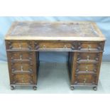 An early 20thC oak tooled leather inset twin pedestal desk with graduated drawers, W122 x D67 x H80