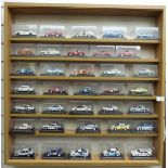 Seventy diecast model rally cars, all in original display boxes and in two glazed wooden display
