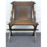 Victorian carved oak Glastonbury chair with Latin motto, W70 x D52 x H87