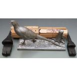 A silvered metal model of a pheasant on naturalistic base together with two cast shotgun lock