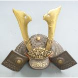Japanese cast iron Samurai helmet with large brass maedate and embossed decoration, 23cm tall.