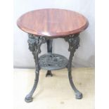 A cast iron pub type table with mask decoration, diameter 60 x H71cm