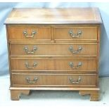 A reproduction mahogany bachelor's chest of two over three graduated drawers raised on bracket feet,