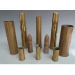 Eight brass shell casings including British six pounder dated 1916 and a German 1917 example,