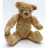 Vintage straw-filled Teddy bear with blonde mohair, glass eyes and jointed limbs, 29cm tall.