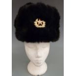 Two Russian fur hats with military/ political badge to front and quilted lining