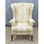 An upholstered wing back armchair, H97cm