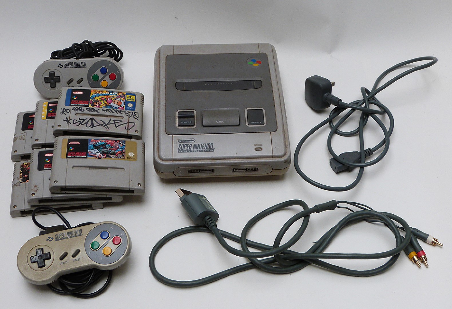 Super Nintendo Entertainment System (SNES) video games console with two controllers and six games.