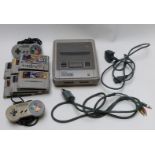 Super Nintendo Entertainment System (SNES) video games console with two controllers and six games.