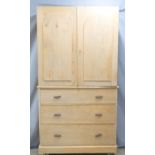 A 19th/20thC two part pine housekeeper's cupboard over a chest of three straight drawers with four