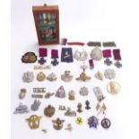 Collection of metal and cloth badges, mainly British Army including Highland Light Infantry,