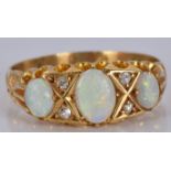 An 18ct gold ring set with three opals and diamonds, 2.9g, size M