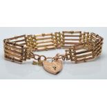 A 9ct gold bracelet with heart clasp and engraved links, 18.4g