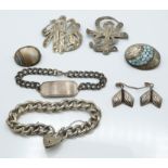 A group of silver jewellery to include two Japanese brooches, curb link bracelet, identity bracelet,