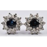A pair of 18ct white gold earrings each set with a sapphire surrounded by diamonds, diameter 0.5cm