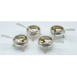 A set of four hallmarked silver salts raised on hoof feet and with shell decoration, together with