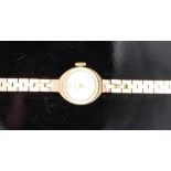 Garrard 9ct gold ladies wristwatch with gold hands and hour markers and silver dial, on 9ct gold