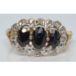 A 9ct gold ring with three oval cut sapphires surrounded by diamonds, 2.4g, size M