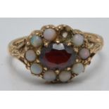 A 9ct gold ring set with a garnet and opals, in antique Cardiff ring box