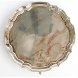 Elizabeth II hallmarked silver card tray or small salver with shaped edge and raised on four feet,