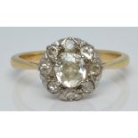 An 18ct gold ring set with an old cut diamond of approximately 0.4ct surrounded by further diamonds,