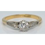 An 18ct gold ring set with a diamond of approximately 0.2ct and a further diamond to each