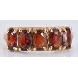 A 9ct gold ring set with five oval garnets, 2.8g, size R