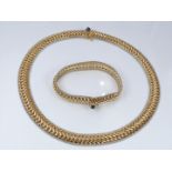 An 18ct gold necklace made up of chain links with a white gold border, set with a sapphire