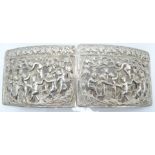 Continental white metal belt buckle with cast and pierced decoration of children celebrating the