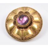 Victorian Etruscan Revival brooch set with a foiled garnet cabochon, verso glass compartment, 9.