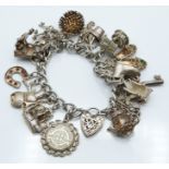 A silver charm bracelet with over 20 silver charms, 83g