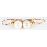 A pair of 18ct gold earrings set with a pearl to each