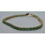 A 9ct gold tennis bracelet set with oval emeralds