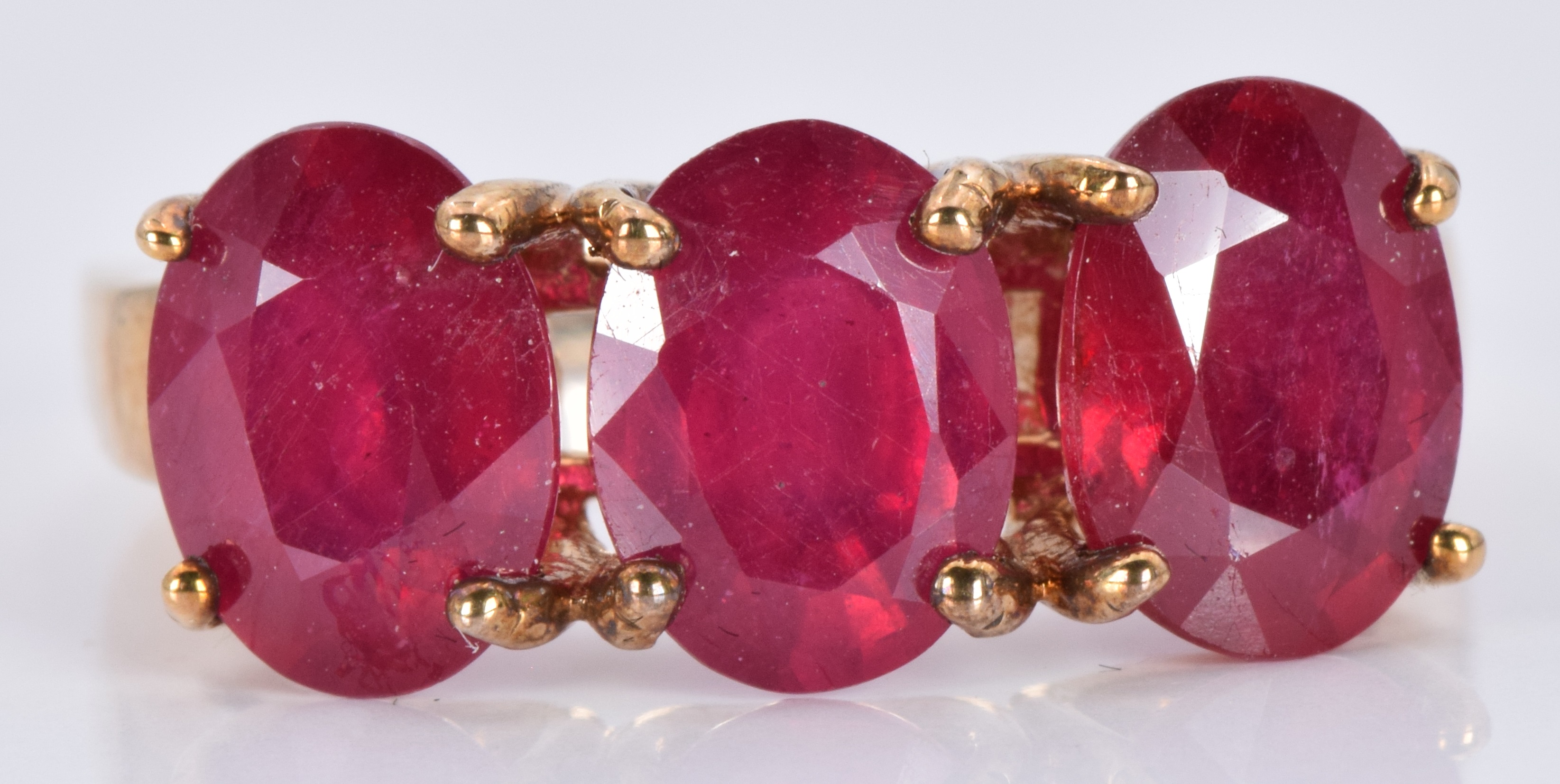 A 9ct gold ring set with three oval rubies, 3.7g, size J