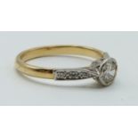 An 18ct gold ring set with a round cut diamond of approximately 0.6ct and with diamond encrusted