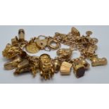 A 9ct gold charm bracelet with over 21 charms including St Christopher, carriage, fob, cockerel,