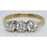 An 18ct gold ring set with three round cut diamonds of approximately 0.25ct, 0.2ct and 0.2ct, 2.