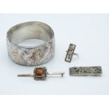 A silver bangle with engraved and rose gold applied decoration, two brooches and a marcasite ring