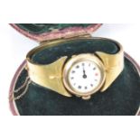 Edwardian 9ct gold watch set into a yellow metal bangle, in original box. 22.6g (Bangle sizing-