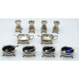 Extensive George V hallmarked silver cruet set comprising four peppers, four open salts with blue
