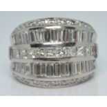 A 14k white gold ring set with round, princess and baguette cut diamonds, total diamond weight