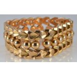 An 18ct gold bracelet made up of spherical and triangular links, 57.4g