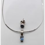 An 18ct white gold pendant set with an oval cut sapphire of approximately 0.75ct and an earring